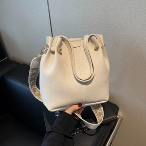 Chic beige lychee leather bucket bag with gold rivets and vintage ethnic wide strap