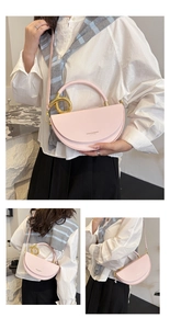 Detail of pink PU leather saddle bag featuring a large gold metal ring and crossbody strap