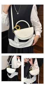 Detail of cream saddle bag with round gold handle and leather texture finish