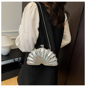 Sac pochette argenté en forme de coquille avec texture radiale et chaîne sur modèle