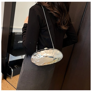 Detailed view of silver metallic shell clutch with water ripple texture and chain strap
