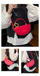 Model showcasing a vibrant red saddle bag with a golden circular handle and leather texture