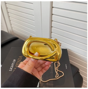 Detail of a mini gold mirror evening bag with top handle and fine metal chain strap