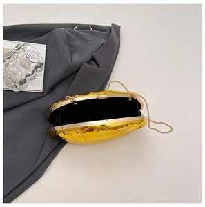 Macro detail of golden oval chain bag featuring high-gloss mirror finish and metal clasp