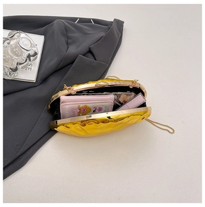 Detail view showing storage capacity of a gold metallic shell evening clutch with chain