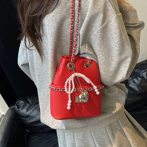 Red pebbled leather bucket bag with chain strap and pearl bow pendant decoration