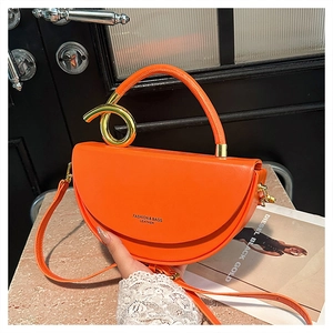 Detail showing orange leather saddle bag with gold metal ring and handle design