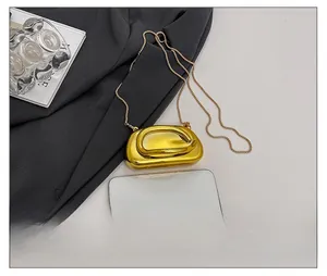 Micro metallic gold evening clutch bag size comparison with a smartphone and chain strap