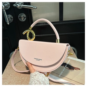 Detail of pink half-moon leather bag featuring gold irregular metal handle and logo