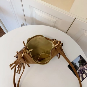 Minimalist brown faux suede shoulder bag with elegant tassel details and top zip closure
