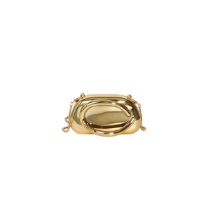 Close-up of golden mirror finish mini evening bag with round handle and chain strap