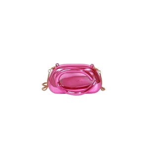 Macro view of bright hot pink mirror finish bag with hollow circular handle and gold chain