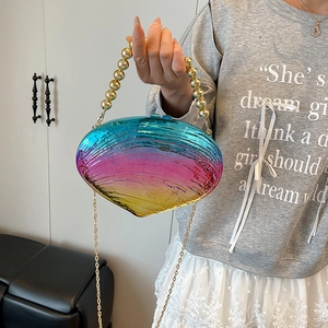Shell-shaped acrylic evening clutch featuring tricolor gradient and golden beaded handle