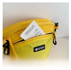Détail de la sacoche de sport en nylon jaune avec poche avant à carreaux et mousqueton
