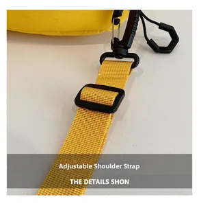 Détail macro de la bandoulière réglable avec boucle en plastique sur sac en nylon jaune