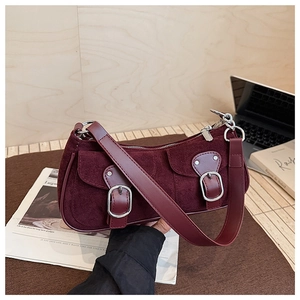 Détail du sac croissant en daim bordeaux avec boucles argentées et texture riche