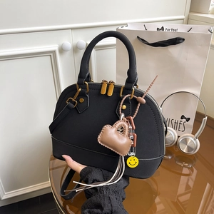 Classic black shell-shaped handbag with matte leather, gold hardware and cute charms