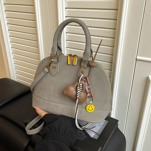 Grey matte vintage shell handbag with decorative charms and adjustable shoulder strap
