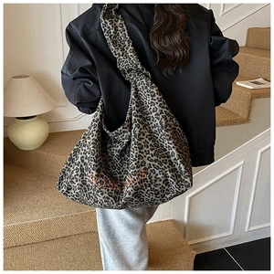 Detailed back view of a oversized leopard print canvas hobo bag worn by a model