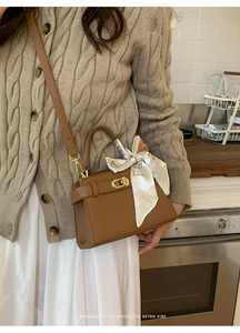 Sac à main marron en cuir avec fermoir doré et foulard en soie élégant sur la poignée