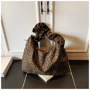 Detail of leopard print tote bag featuring pleated cloud handle and orange embroidery