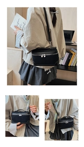 Détail du sac bandoulière en toile noire avec fermetures éclair coeur argentées et poignées
