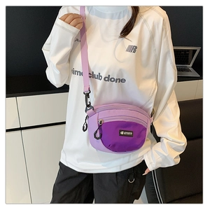 Détail d'un sac bandoulière en tissu oxford violet avec sangle réglable sur chemise blanche