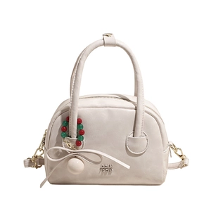 Sac oreiller blanc crème à la mode avec pendentif perlé et logo doré sur fond blanc