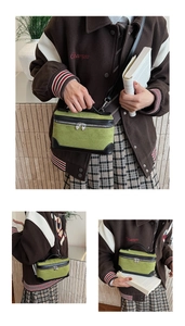 Détail du sac à main en daim vert mousse avec zip en forme de cœur et bordure en cuir noir