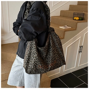 Detail of leopard print tote bag featuring embroidered DCERYVALS text and soft canvas texture
