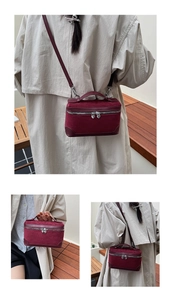 Détail du sac bandoulière bordeaux en daim avec fermeture cœur argentée et renforts cuir