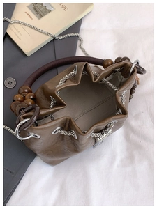 Macro view of dark brown bucket bag with wooden beads and herringbone fabric lining
