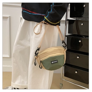 Détail du sac bandoulière nylon beige et olive montrant la sangle réglable et le logo