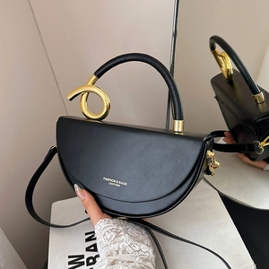 Fashionable black leather half-moon saddle bag with large decorative gold metal rings