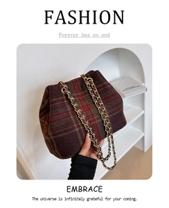 Detailed view of British plaid bucket bag with gold chain strap and woolen texture