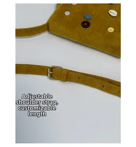 Detail of adjustable shoulder strap and yellow faux suede texture with decorative buttons