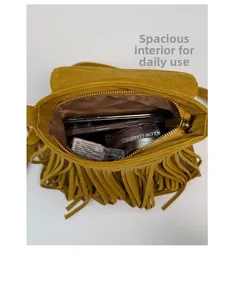 Detail view of mustard yellow tassel crossbody bag showing spacious interior compartment