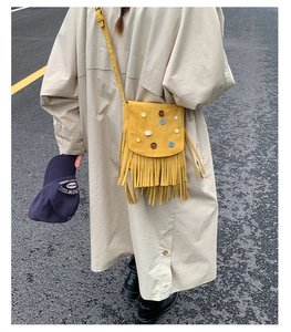 Street style view of ginger suede crossbody bag with fringe and colorful button details