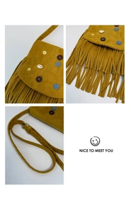 Detail of bohemian yellow suede bag with colorful buttons, shells and long tassels
