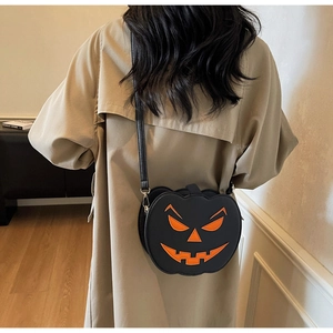 Détail d'un sac bandoulière citrouille noir avec visage Jack-o'-lantern orange sur un manteau