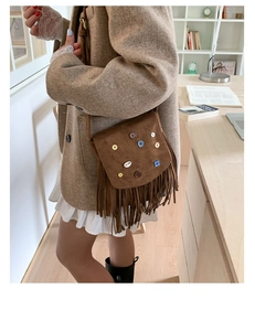 Detail of bohemian brown suede crossbody bag with colorful patchwork and long tassels