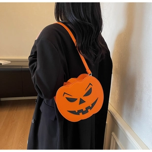 Vue latérale d'un sac bandoulière orange en forme de citrouille porté sur un manteau noir