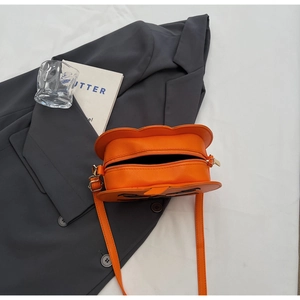 Détail du sac citrouille avec texture gaufrée et broderies noires de visage cartoon