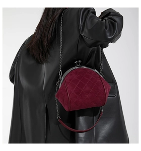 Dettaglio della borsa in pelle scamosciata bordeaux trapuntata con catena sulla modella