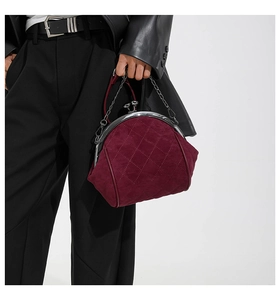 Dettaglio della borsa a tracolla in pelle scamosciata bordeaux con motivo trapuntato