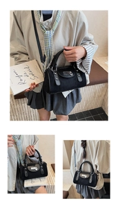 Détails du sac boston noir avec pendentif en cœur et ornements en métal argenté brillant