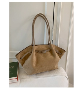 Close-up of matte suede tote bag with slim shoulder straps and buckle detail