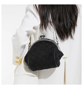 Detail of black quilted velvet shell bag with vintage metal kiss-lock and chain strap