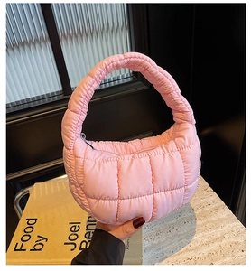 Detail of pink quilted cloud bag featuring soft polyester fabric and square stitching