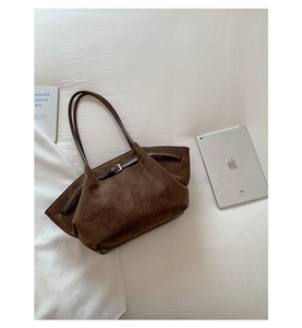 Detailed macro of dark coffee suede tote bag with silver buckle and matte vintage texture